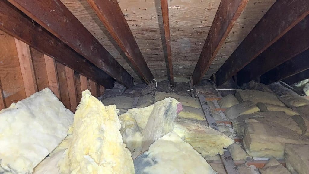 Wide view of new insulation batts installed across attic floor joists in Scarsdale, NY