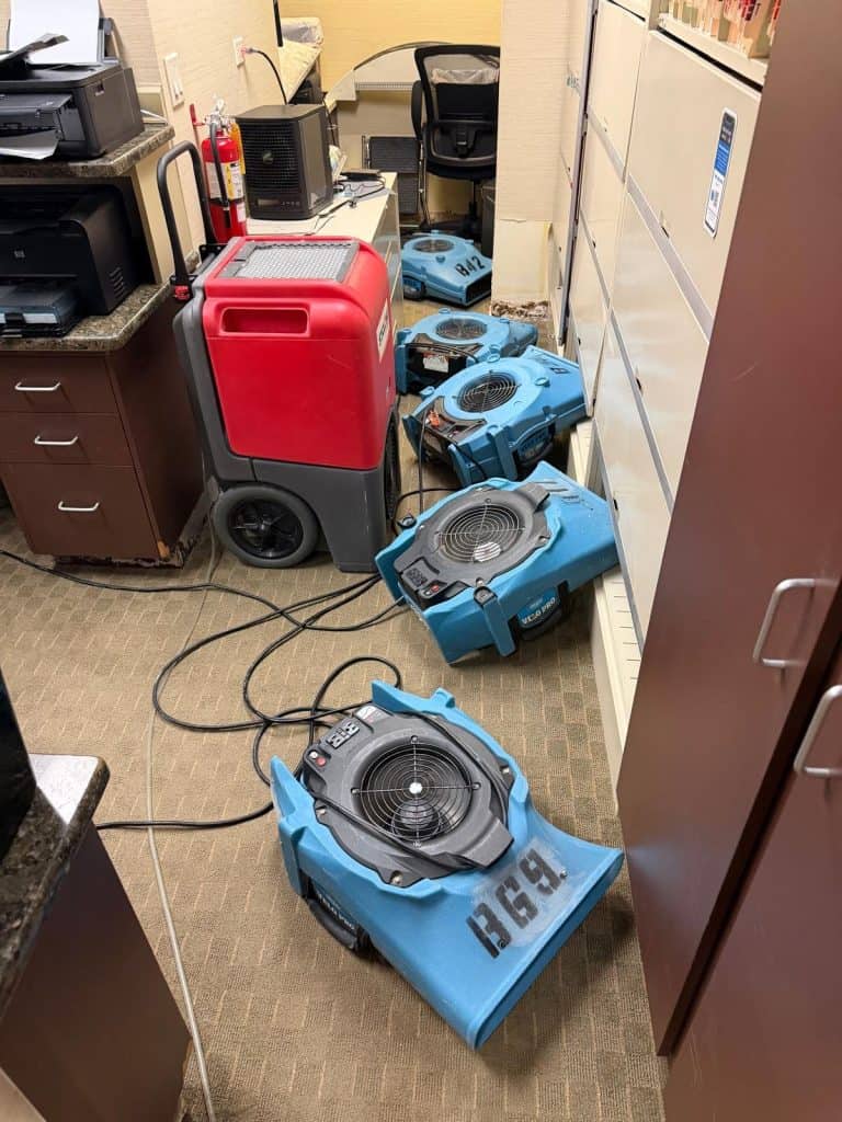 Dehumidifier and air movers drying a dental office reception area after water damage in Armonk, NY