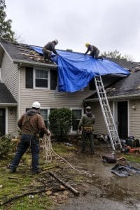 Bowerman crew installing an emergency roof tarp on a storm-damaged home during storm surge flood restoration