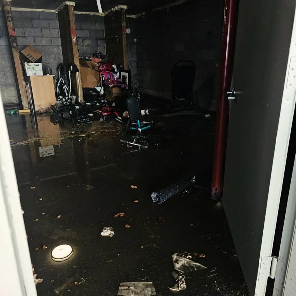 Floodwater covering a city building basement storage area after a severe storm