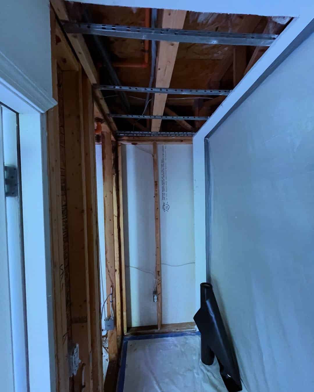 Hallway with ceiling and walls opened for drying after urban flood cleanup