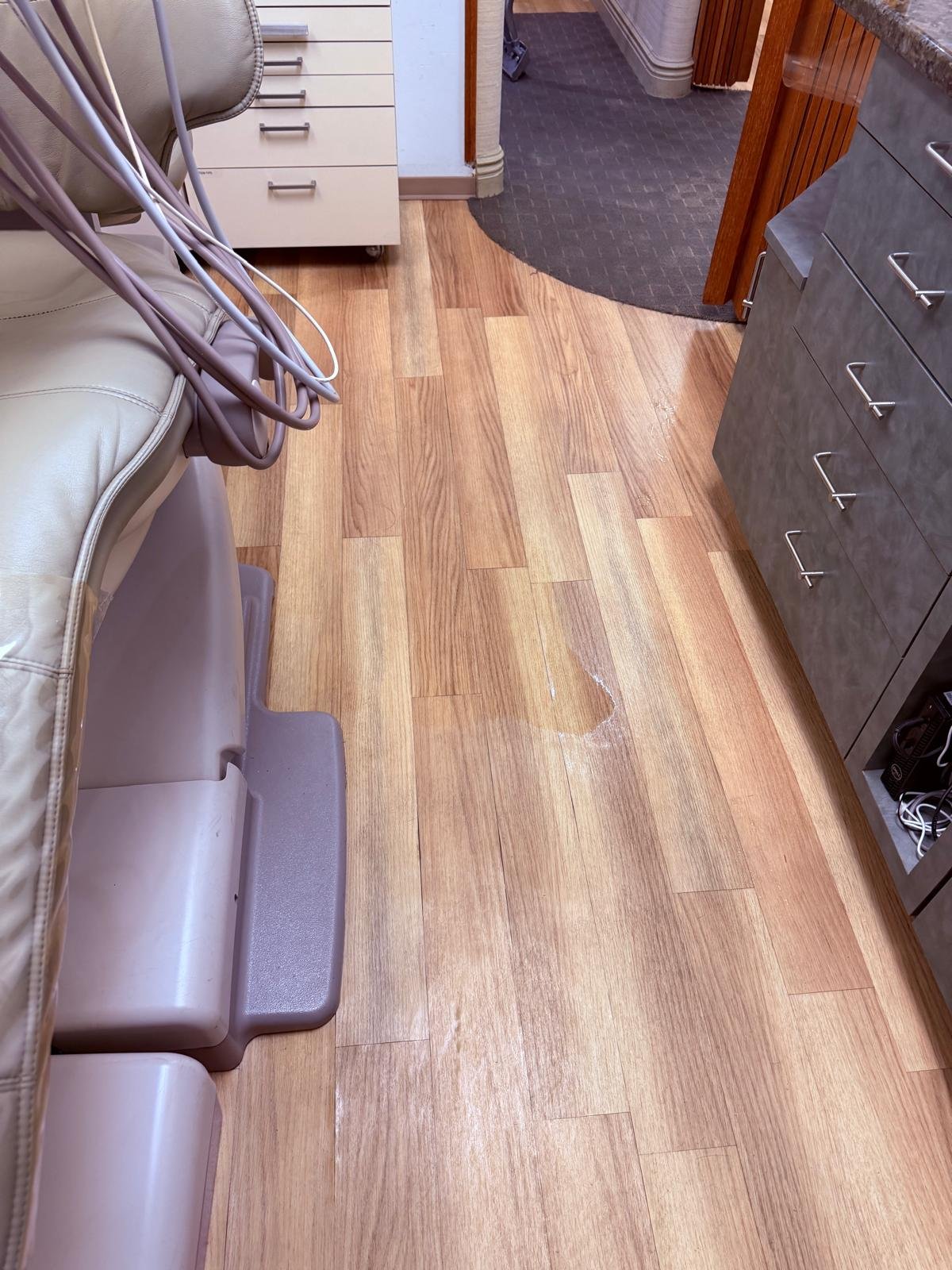Wet vinyl floor beside a dental chair in an Armonk, NY exam room